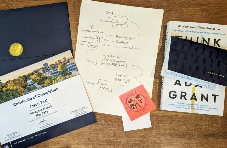 A picture of documents on a table including a certificate for 'managing at UBC' leadership program.